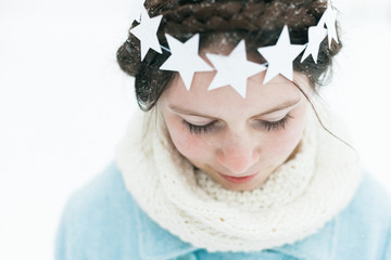 Little girl wearing a star wreath in the snow