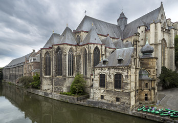 Fototapeta na wymiar Saint Michael's Church at Lys river in Ghent, Belgium. Church and boats on the river side