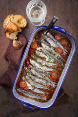 Sardinas en salsa with garlic bead as top view in a skillet