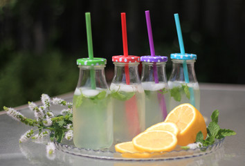 Homemade lemonade in glass bottles on a glass table