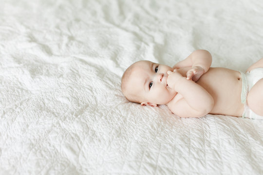 Off centered shot of chubby baby on white blanket