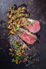 Barbecue wagyu roast beef with chanterelle as top view on a  board