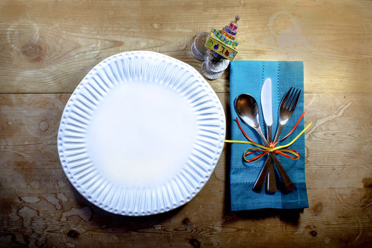 Rustic genuine casual Hanukkah meal place setting with handmade plate and enameled dreidel
