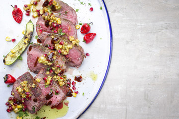 Australian barbecue dry aged Kobe chateaubriand steak with vegetable and fruit relish as close-up on a white plate .
