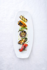 Traditional Italian barbecue antipasti creative decorated as top view on a white plate