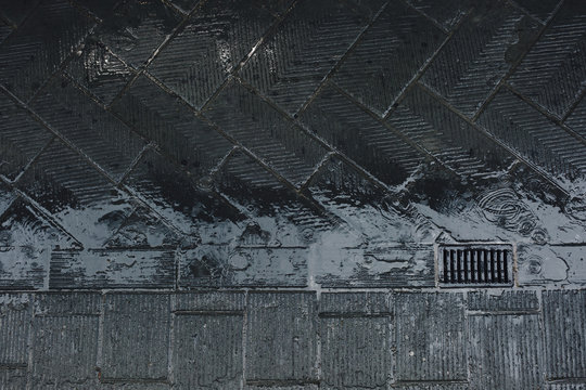 Wet pavement on the street in the rain with a drain