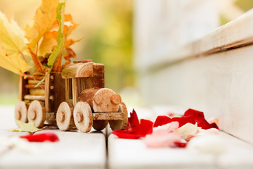 Concept design autumnal mood, yellow foliage on a background and a toy train. Fall October or November.