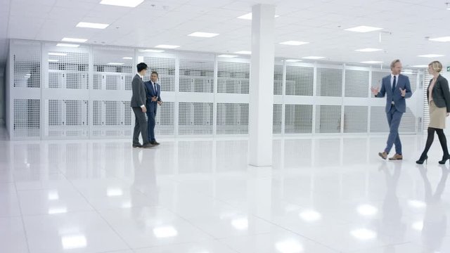 Business people looking around large modern data center with rows of server racks.