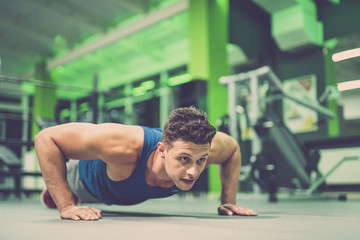 The sportsman doing push up exercise in the gym