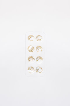 Hand cut circles on white background that imitate a blister pack with full of unordered medicine