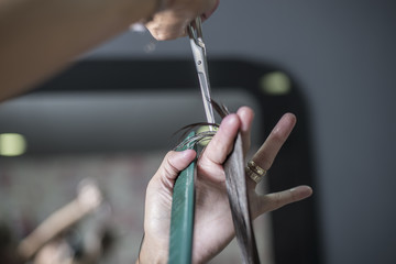 A Hairdresser in action cutting long hair