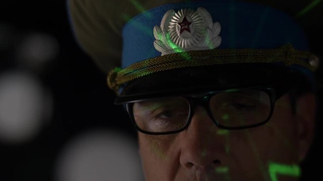SOVIET COMMANDER LOOKING AT A SONAR SCREEN.  Version 2 of 2.  Model release.  ECU on face with sonar light on him.