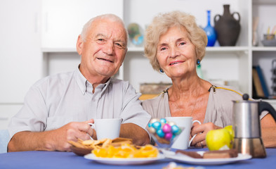 Happy senior couple enjoying conversation over cup of coffee