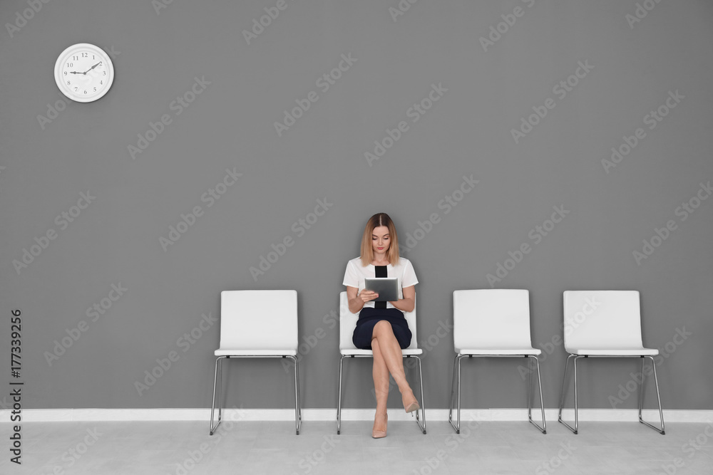 Wall mural Young woman waiting for job interview in hall