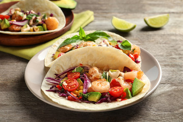 Plate with delicious shrimp tacos on wooden table