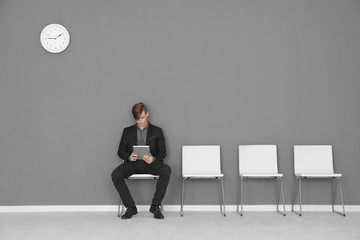 Young man waiting for job interview in hall