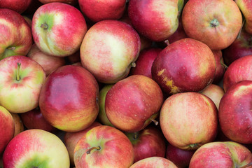 A bunch of beautiful fresh red, yellow, and green apples. Apples are in several layers. Useful fruits for health. Apples are for sale in the market. Food for weight loss.
