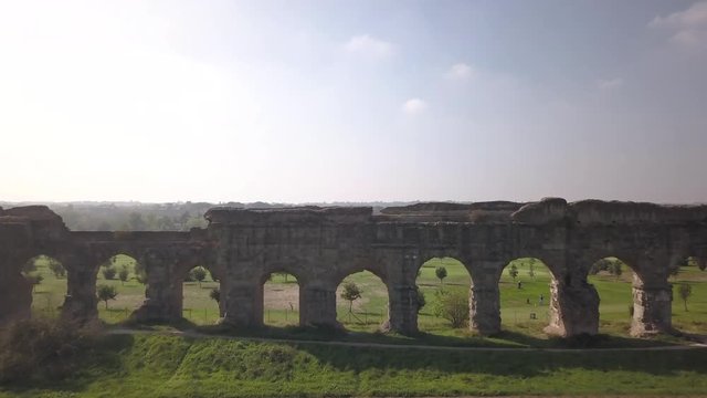 Video from above. Aerial view of the ancient Roman Aqueduct. Old ruins surrounded by a green public Park (Parco degli Acquedotti) Rome, Italy.	