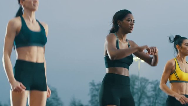  Female athletes warming up at running track before a race