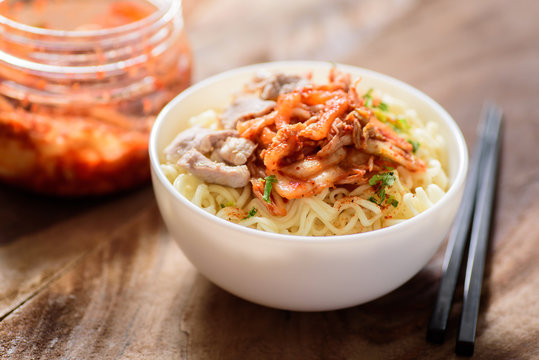 Korean food,instant noodle with kimchi cabbage in a bowl on wooden background