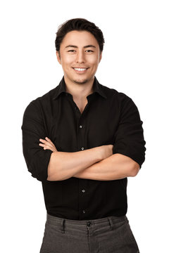 Attractive man in a black shirt and grey pants, standing with a big smile against a white background,