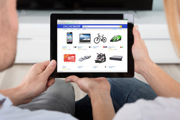 Couple Looking At House With Digital Tablet