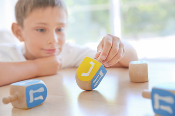 Jewish boy playing with dreidel at home © Africa Studio