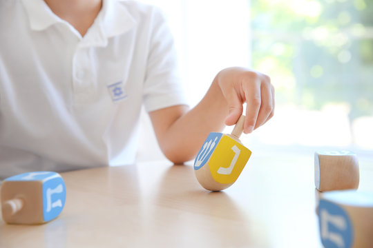 Jewish boy playing with dreidel at home