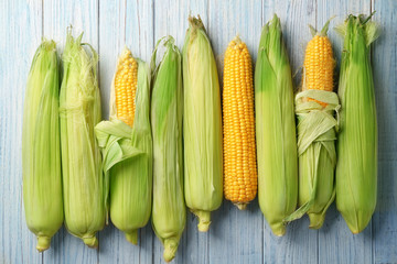 Fresh corn cobs on wooden table
