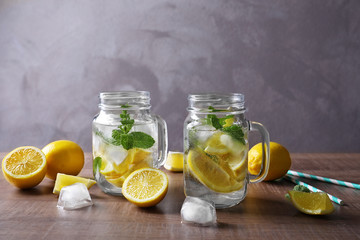 Mason jars with mojito cocktail on wooden table