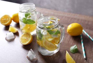 Mason jars with mojito cocktail on wooden table