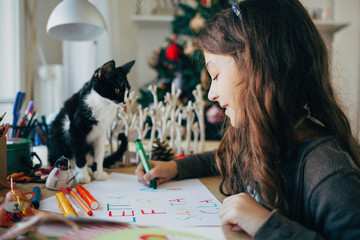 Girl and Her Kitten Writing a Letter to Santa