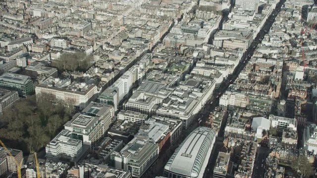  Aerial view above commercial buildings & traffic in central London, England