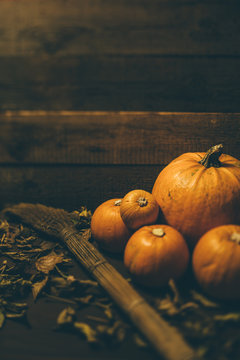 Bunch of pumpkins and broom on wooden background