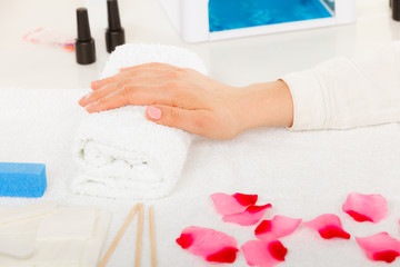 Obraz na płótnie Canvas Woman hand on towel, next to manicure set