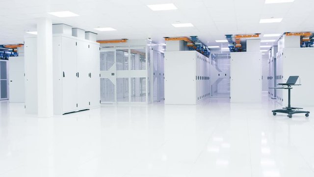 Empty interior of large modern data centre with rows of server racks.