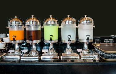 Variety of juice in beverage dispenser for breakfast.