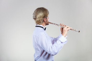 Male flutist playing his flute