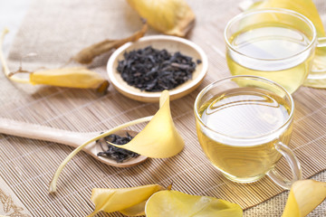 Autumn tea. Glass teapots and cups with autumn leaves on table.