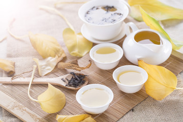White tea cups and autumn leaves on the table. Autumn tea.