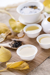 White tea cups and autumn leaves on the table. Autumn tea.