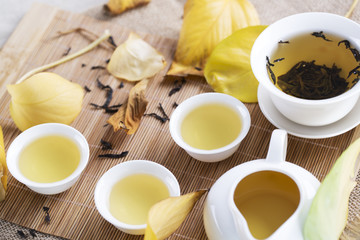 White tea cups and autumn leaves on the table. Autumn tea.