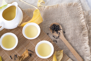 Top view of white tea cups and autumn leaves on the table. Autumn tea.