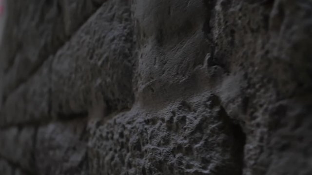 The old brick wall background. Ancient building in gothic quarter of Barcelona. Slow motion. the camera moves from right to left.