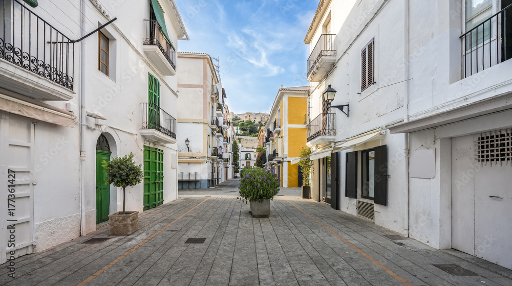 Wall mural typical empty street in old town of ibiza, balearic islands, spain. morning light.