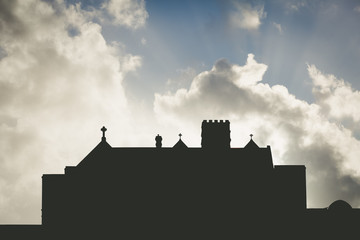 Obraz premium Church building silhouette at sunset with beautiful clouds and s