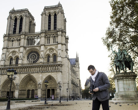 Tourist Photographing Notre Dame de Paris with Vintage Medium Format Film Camera