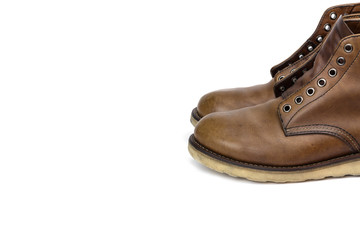old brown leather boots on white background, vintage style concept.