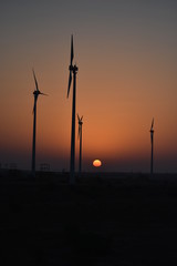 Fototapeta na wymiar sunrise with modern wind mills in great thar desert jaisalmer rajasthan india