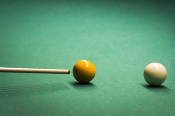 Colored balls on a green billiard table close-up.